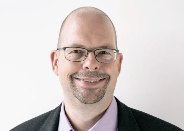 Profilbild von Harald Meyn: Ein Mann mit Brille und Bart lächelt in die Kamera.