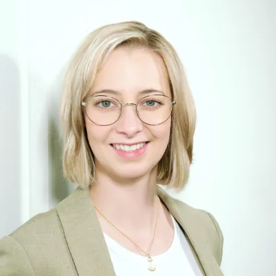 Lisa Isleib - Beraterin bei orgalean: Eine blonde Frau mit Brille lächelt in die Kamera.