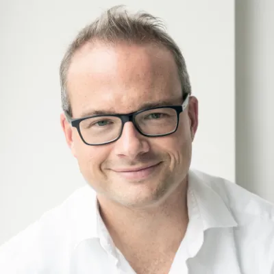 Nicolai Rathmann - Geschäftsführer orgalean GmbH: Ein Mann mit Brille lächelt in die Kamera.
