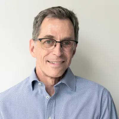Robert Freier - Partner bei orgalean: Ein Mann mit Brille lächelt in die Kamera.