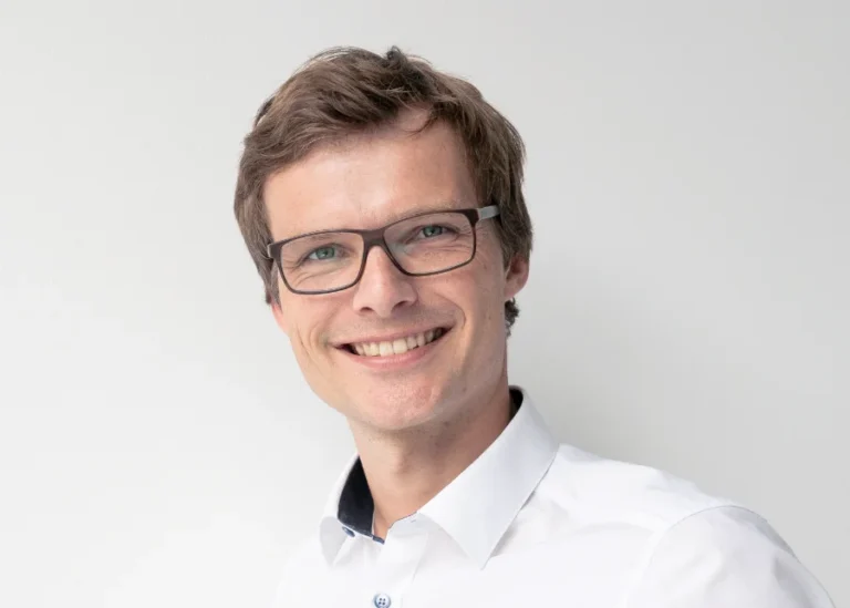 Profilbild von Torben Kruel: Ein Mann mit Brille lächelt in die Kamera.