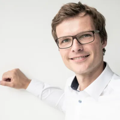 Torben Kruel - Berater bei orgalean: Ein Mann mit Brille lächelt in die Kamera.