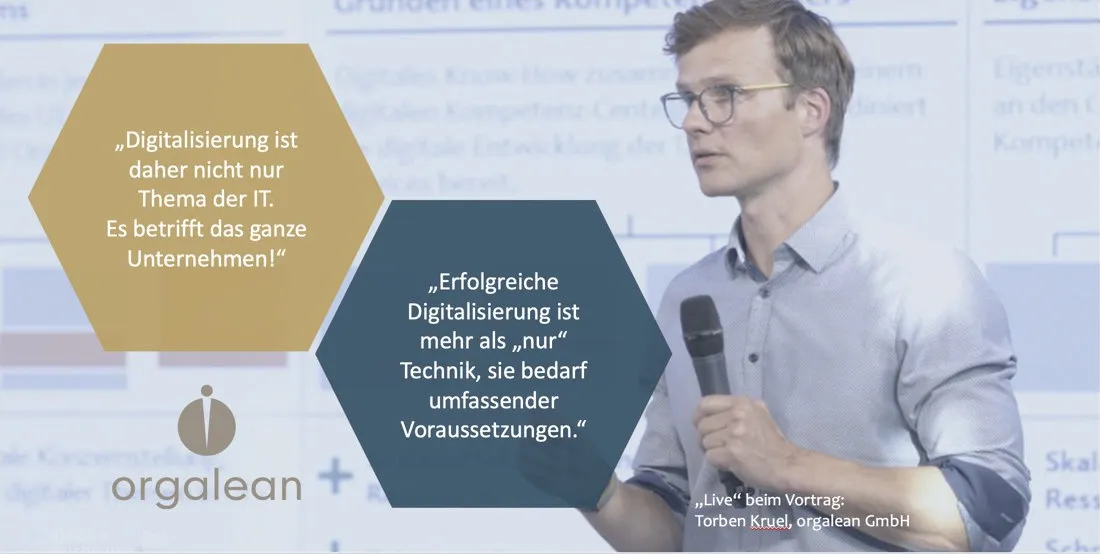 Torben Kruel auf der Bühne bei seinem Vortrag zum Thema Digitalisierung an der ScienceFor Society in Kiel 2022. Ein Mann steht rechts im Bild mit einem Mikrofon in der Hand auf einer Bühne und hält einen Vortrag. Links sind 2 Zitate in Wabenfeldern zu lesen, unten befindet sich das Logo der orgalean GmbH.